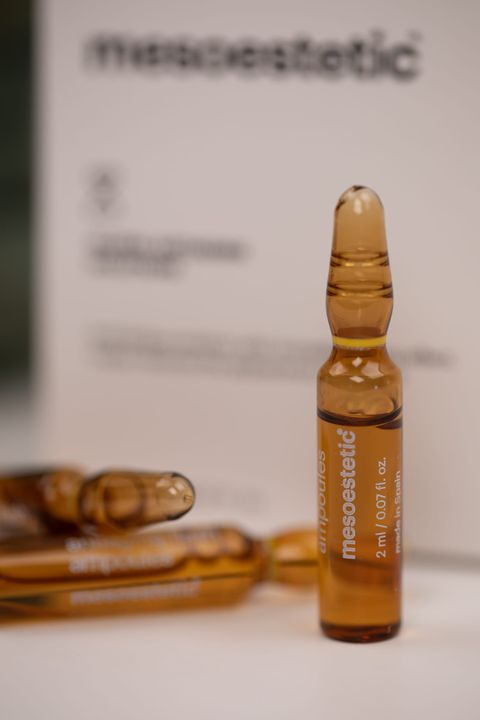 Ravfarvet ampul fra Mesoestetic foran den hvide æske